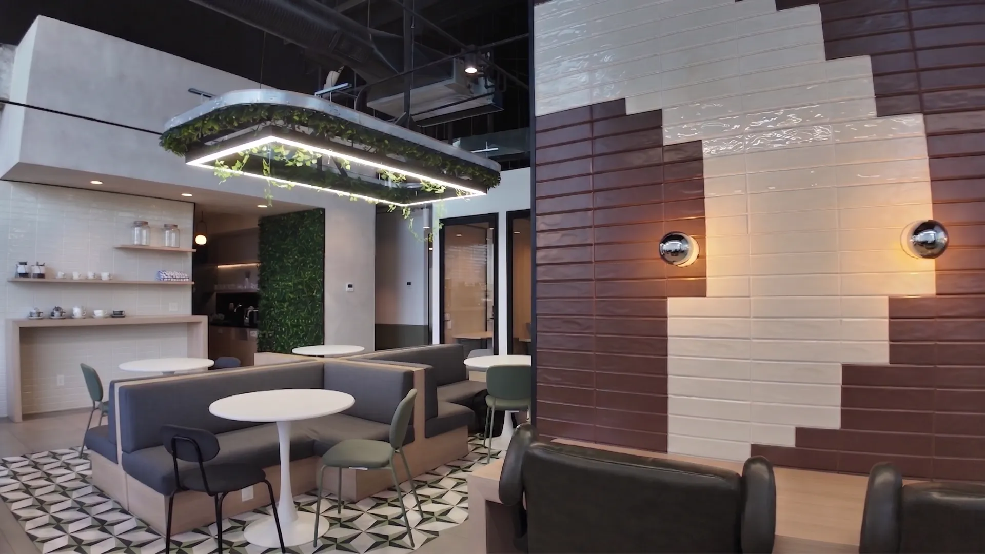 Sala común con sofás, barra de café y piso de mosaico en Think Workspace